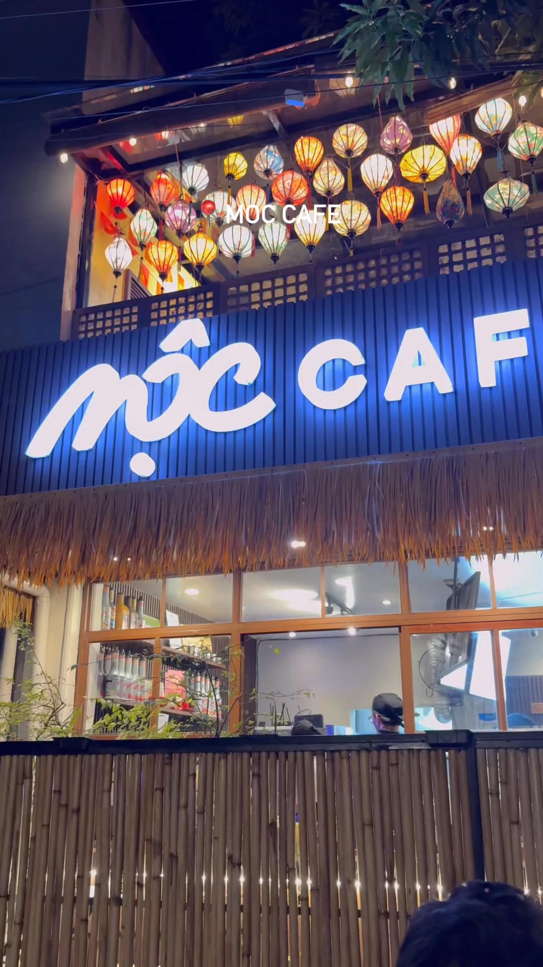 MỘC Cafe exterior at night with illuminated neon sign
